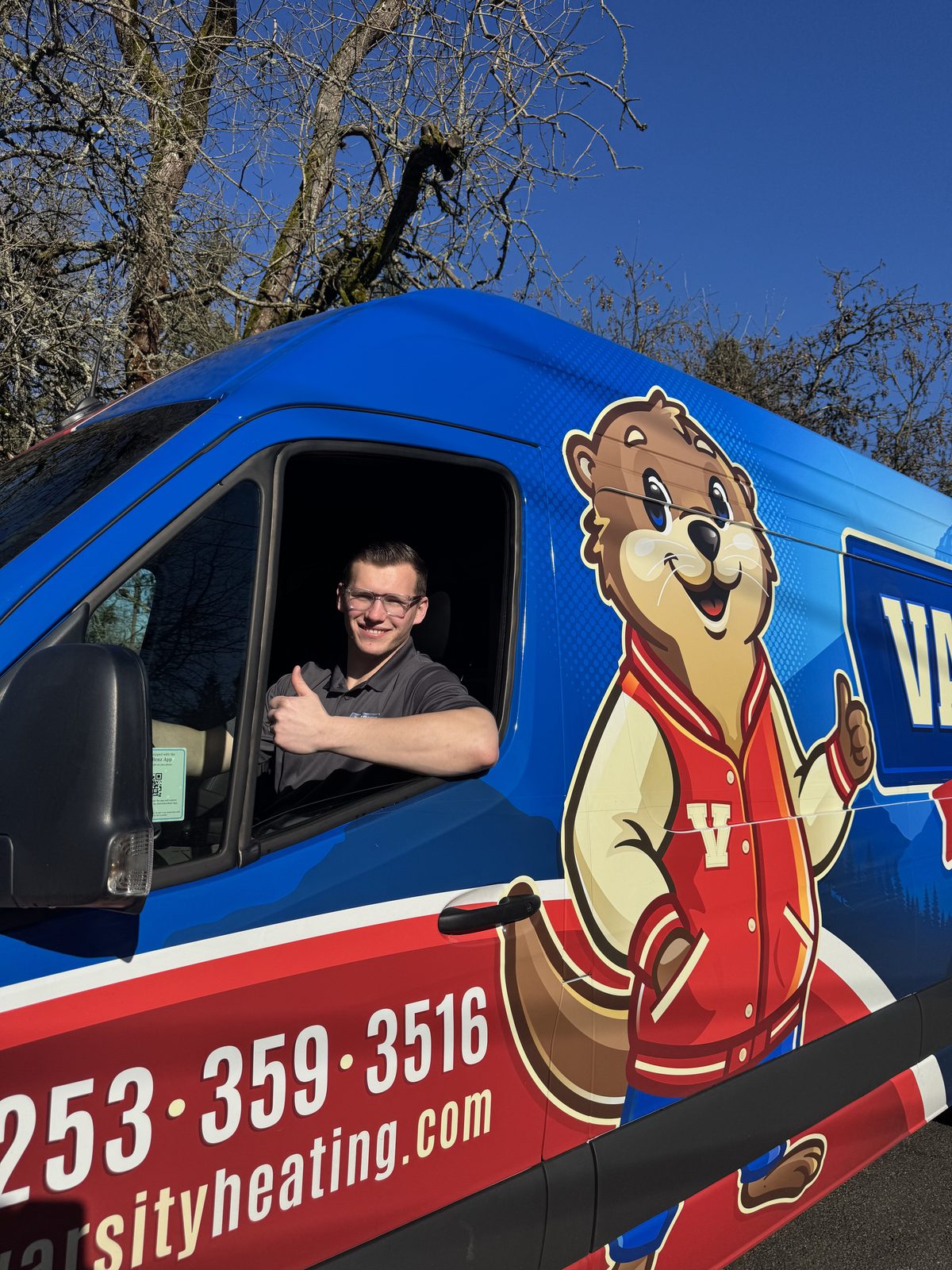 Jake from Varsity giving a thumbs-up from the driver's seat of a Varsity van